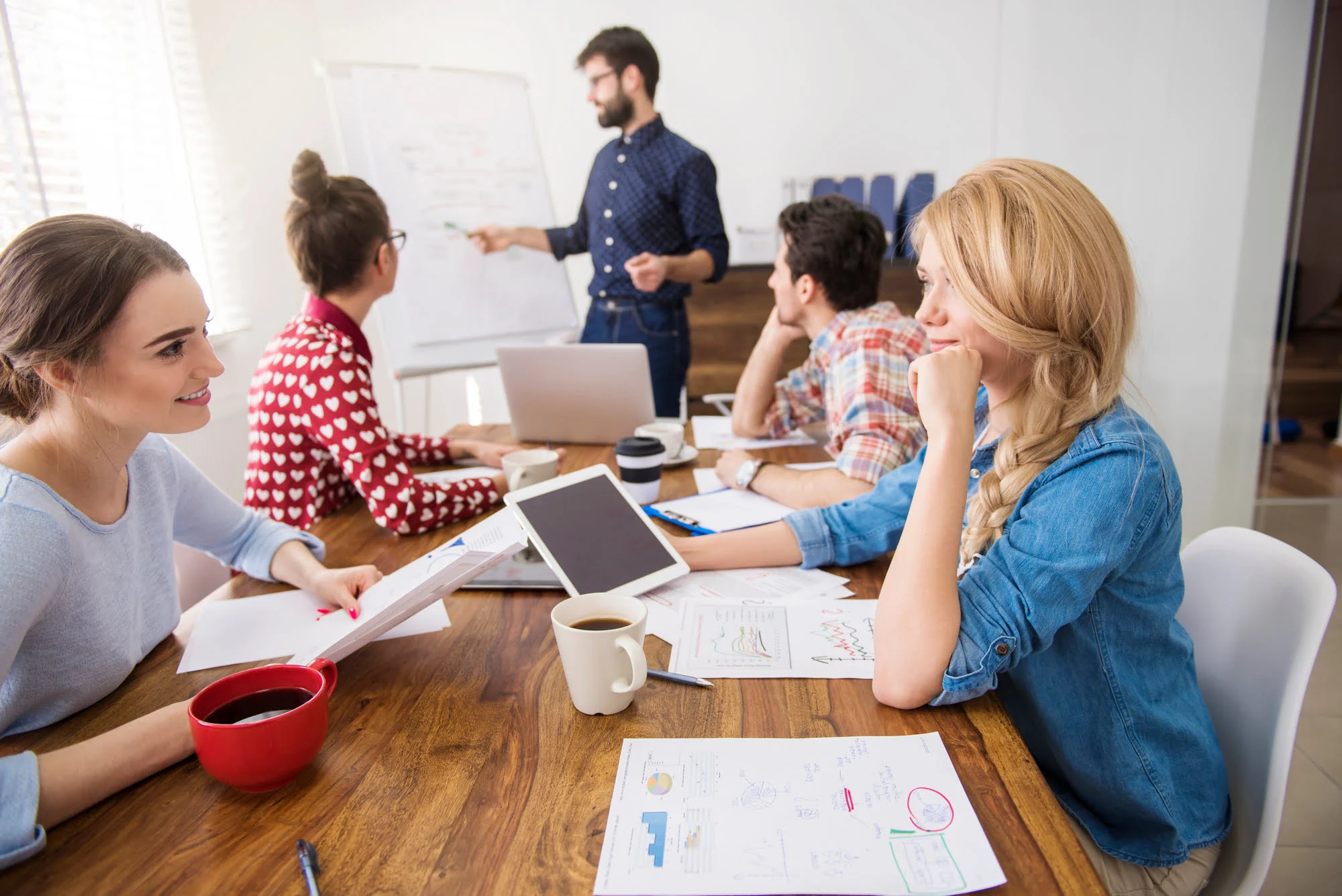 Zespół pracowników w biurze omawiający system wsparcia dobrostanu i wellbeing w firmie